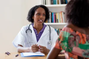 doctor talking to a patient about the recovery time for a monsplasty in los angeles