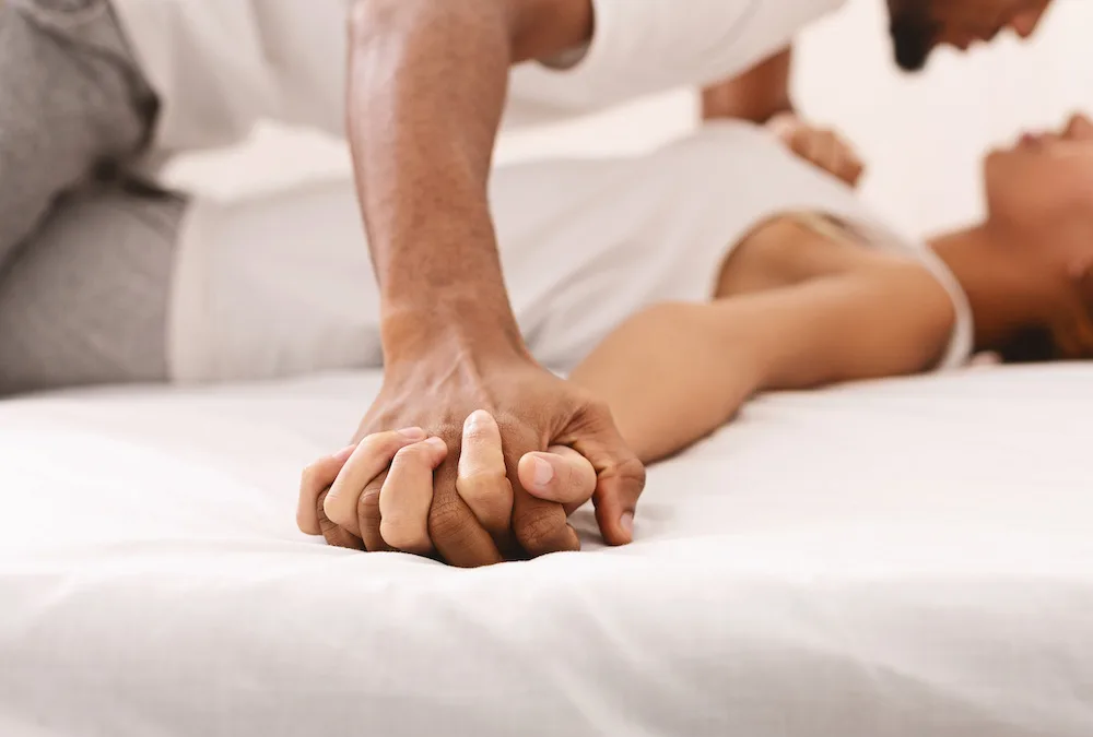 Passionate african couple making love in bed, intimate foreplay