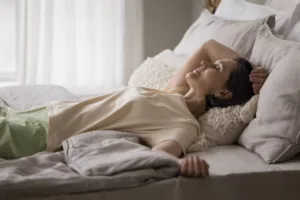 woman laying in bed after a labia puffing procedure