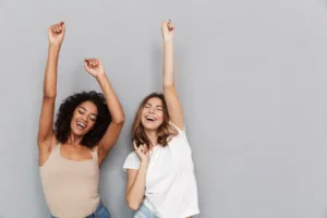 Two women expressing joy through their positive energy.