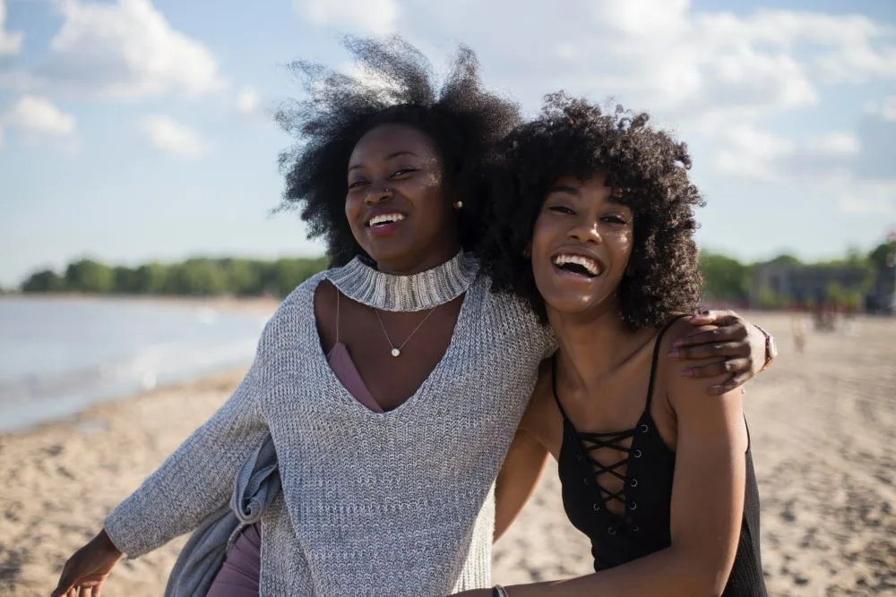 Two friends excited to hang out on the beach together.
