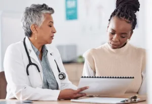 A woman speaking to her doctor about her treatment schedule.