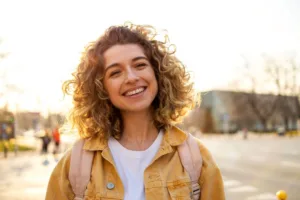 A young woman smiling while walking around town.