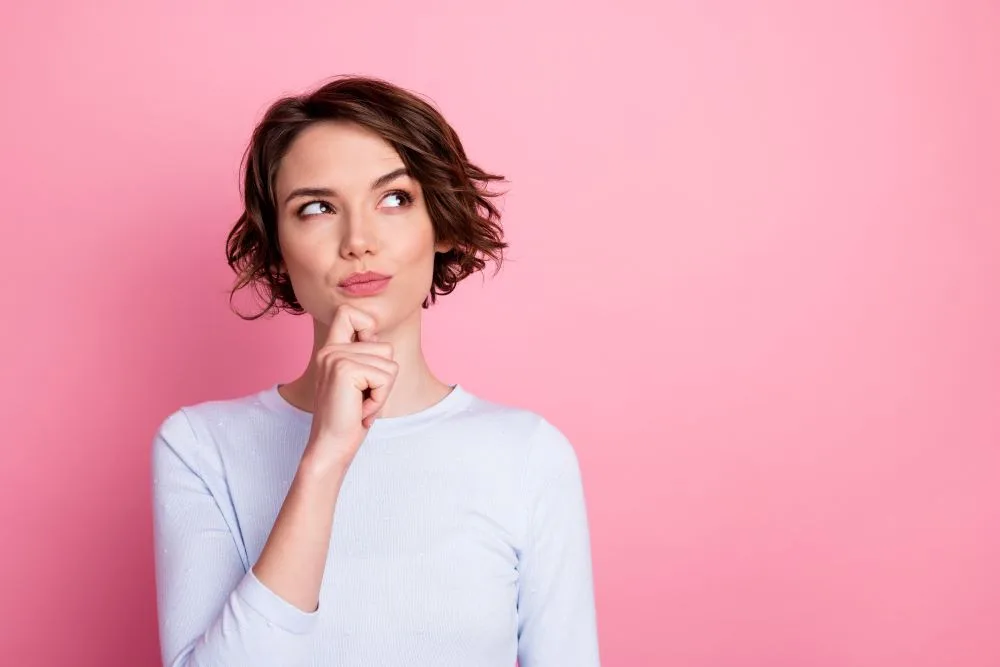 A woman holding her hand to her chin thinking about an idea she had.