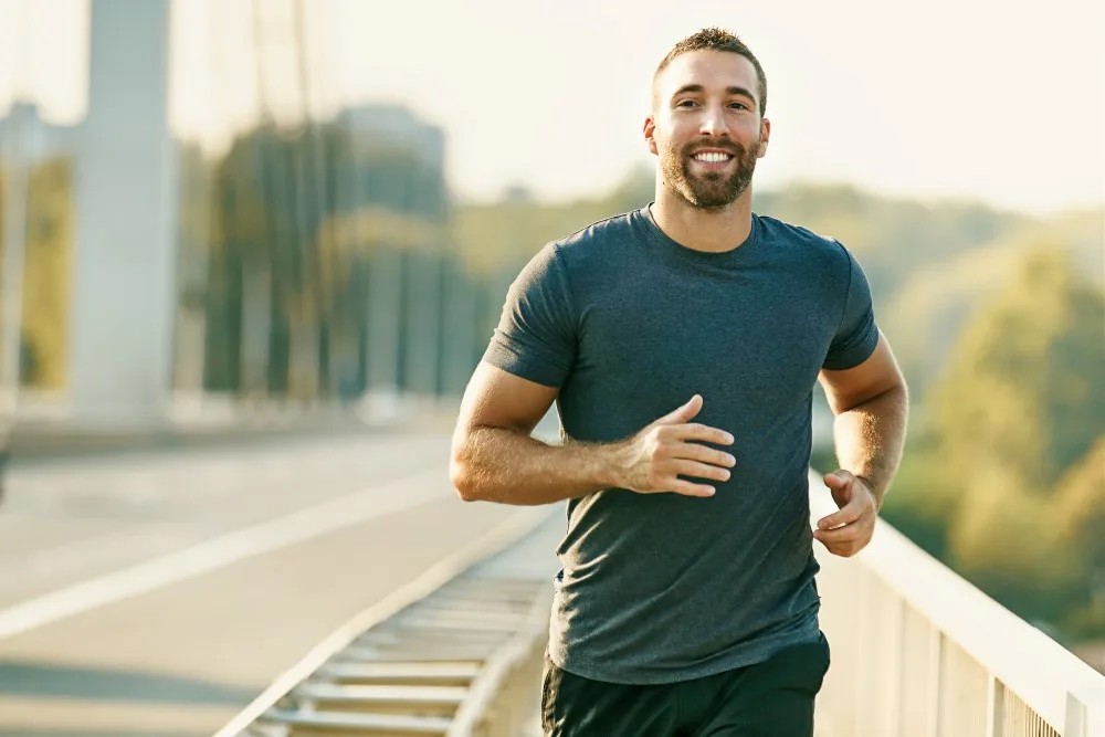A man running around his neighborhood as a form of exercise.
