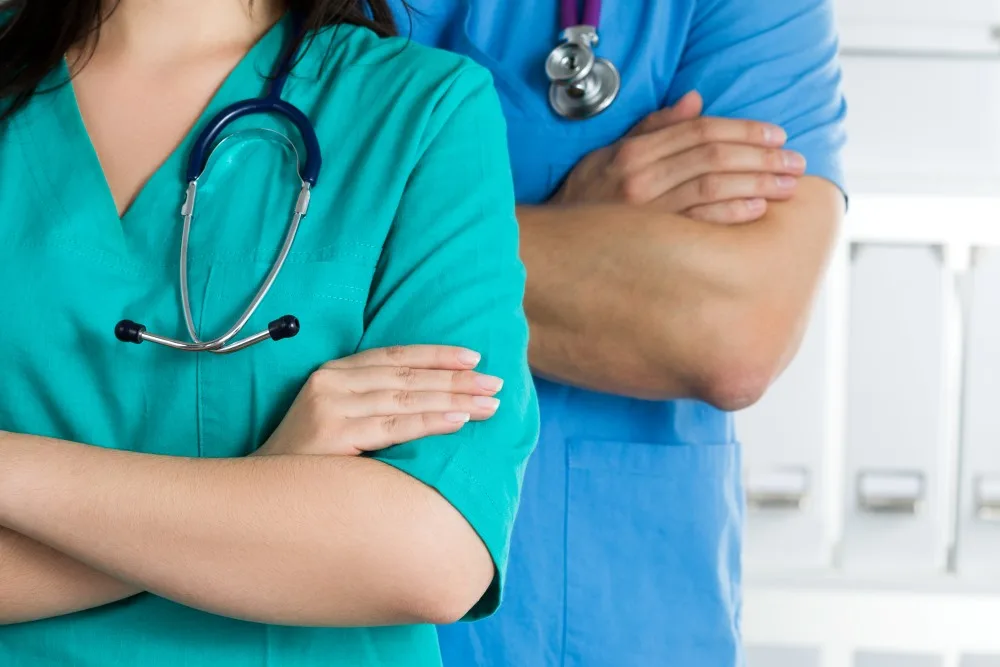 Two doctors standing with their arms crossed on chest.