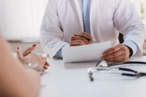 Close up of a female patient discussing treatment plans with doctor and doctor taking notes