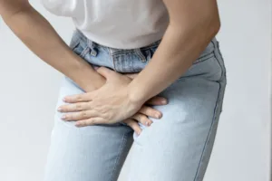 Woman holding her pelvic area. Urinary incontinence concept.